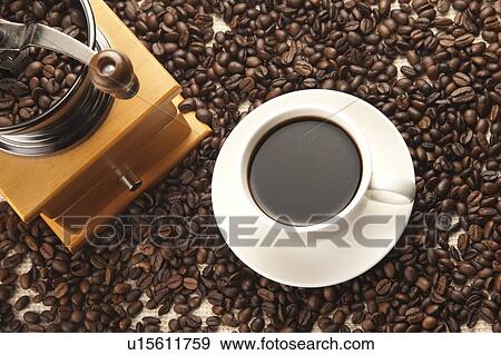 Stock Photo - Coffee, Coffee Bean, Coffee Grinder, A cup of coffee and a coffee grinder on a stack of coffee beans. Fotosearch
