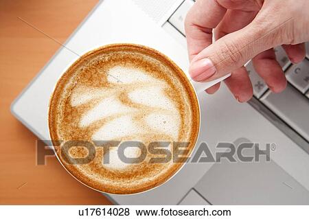 Stock Photo - Coffee, Human hand holding a cup of cappuccino with pattern. Fotosearch