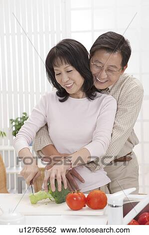 Stock Image - Couple, Couple bonding together and cutting vegetable with smile. Fotosearch