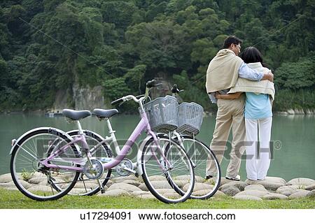 Stock Image - Couple, Couple bonding together near the lake and enjoying beauty in nature. Fotosearch