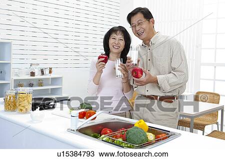 Couple, Couple holding apple and glass of milk with smile View Large Photo Image Stock Image - Couple, Couple holding apple and glass of milk with smile. Fotosearch