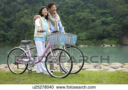 Couple, Couple holding bikes and bonding together with smile View Large Photo Image Stock Image - Couple, Couple holding bikes and bonding together with smile. Fotosearch