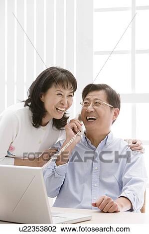 Couple, Couple laughing and on the phone View Large Photo Image Stock Image - Couple, Couple laughing and on the phone. Fotosearch