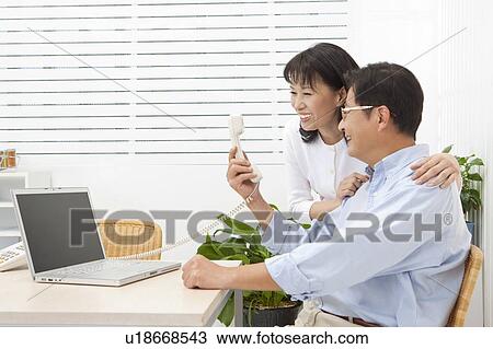 Couple, Couple looking at the telephone with smile View Large Photo Image Stock Image - Couple, Couple looking at the telephone with smile. Fotosearch