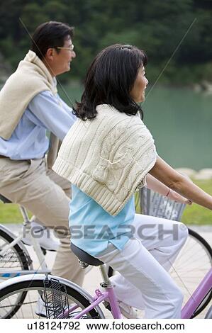 Stock Image - Couple, Couple riding on bikes together. Fotosearch
