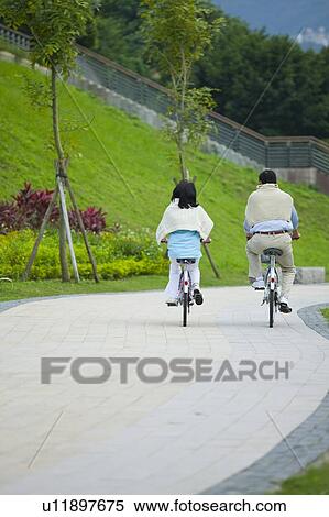 Stock Photography - Couple, Couple riding on the bikes together. Fotosearch