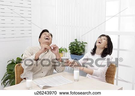 Couple, Couple sitting near the table and laughing with head back View Large Photo Image Stock Image - Couple, Couple sitting near the table and laughing with head back. Fotosearch