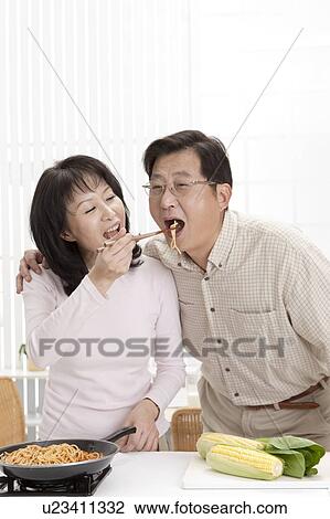 Couple, Wife feeding noodles to husband with mouth open View Large Photo Image Stock Image - Couple, Wife feeding noodles to husband with mouth open. Fotosearch