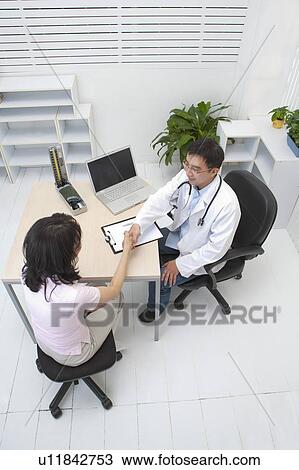 Stock Image - Couple, Woman shaking hands with the doctor. Fotosearch