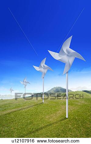 Stock Photograph - Environmental Conservation, Digitally generated image of windmills on the grass. Fotosearch