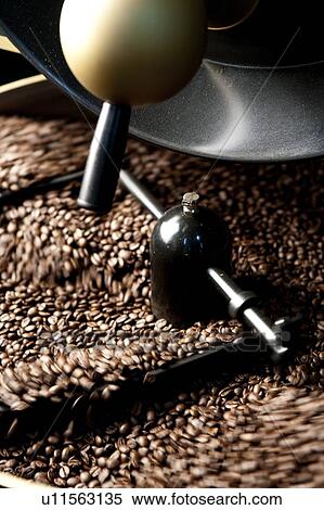 Stock Photography - Food And Drink Industry, Close-up of coffee beans on the roasting machine. Fotosearch
