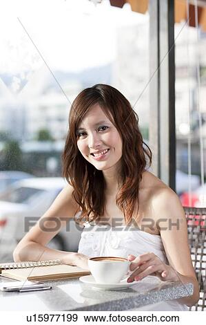 Leisure, Carefree, Relaxation, Coffee Break, Young woman holding a cup of coffee and smiling at the camera View Large Photo Image Stock Photo - Leisure, Carefree, Relaxation, Coffee Break, Young woman holding a cup of coffee and smiling at the camera. Fotosearch