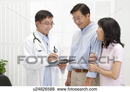 Stock Photo - Medical Exam, Couple going to see the doctor and smiling. Fotosearch