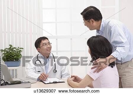 Medical Exam, Husband taking wife to see the doctor View Large Photo Image Stock Photo - Medical Exam, Husband taking wife to see the doctor. Fotosearch