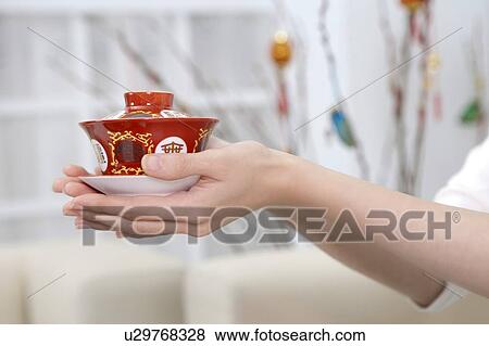 Stock Photo - New Year, Close-up of human hands holding a cup of tea. Fotosearch