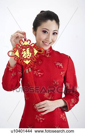 New Year, Young woman wearing Chinese traditional clothing and holding a tassel with smile View Large Photo Image Picture - New Year, Young woman wearing Chinese traditional clothing and holding a tassel with smile. Fotosearch