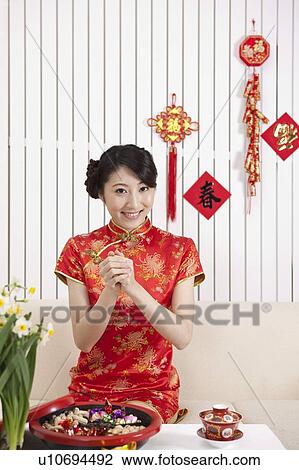 New Year, Young woman wearing Chinese traditional clothing and greeting with smile View Large Photo Image Stock Image - New Year, Young woman wearing Chinese traditional clothing and greeting with smile. Fotosearch