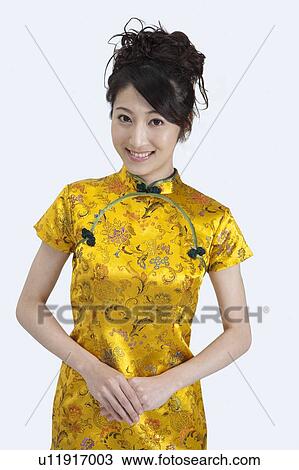 Stock Image - New Year, Young woman wearing Chinese traditional clothing and smiling at the camera. Fotosearch