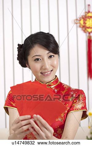 New Year, Young woman wearing Chinese traditional clothing and holding red envelopes with smile View Large Photo Image Stock Image - New Year, Young woman wearing Chinese traditional clothing and holding red envelopes with smile. Fotosearch