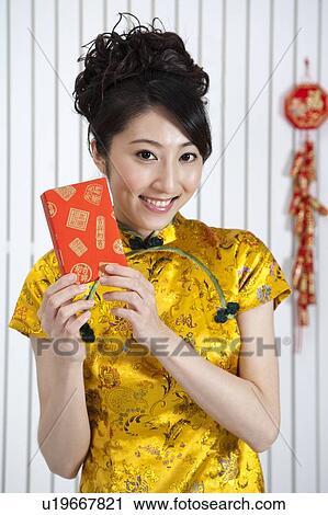 New Year, Young woman wearing Chinese traditional clothing and holding a gift with smile View Large Photo Image Stock Image - New Year, Young woman wearing Chinese traditional clothing and holding a gift with smile. Fotosearch