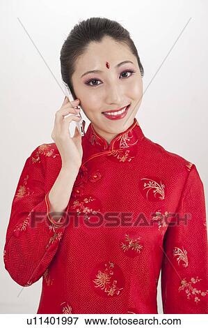 New Year, Young woman wearing Chinese traditional clothing and holding mobile phone with smile View Large Photo Image Stock Photo - New Year, Young woman wearing Chinese traditional clothing and holding mobile phone with smile. Fotosearch