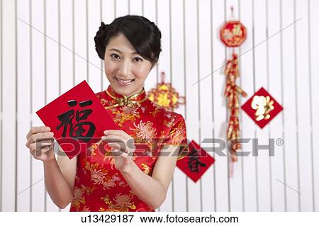 New Year, Young woman wearing Chinese traditional clothing and holding calligraphy with smile View Large Photo Image Stock Photo - New Year, Young woman wearing Chinese traditional clothing and holding calligraphy with smile. Fotosearch
