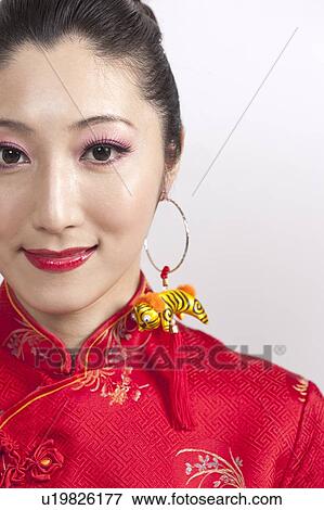 Stock Photo - New Year, Young woman wearing Chinese traditional clothing and smiling. Fotosearch