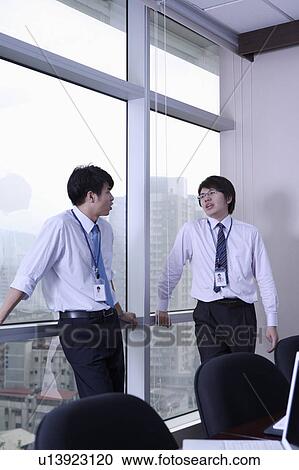 Two businessmen discussing together View Large Photo Image Stock Image - Two businessmen discussing together. Fotosearch