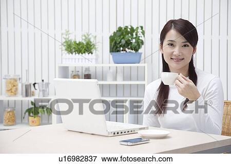 Woman holding a cup and looking at the camera with smile View Large Photo Image Stock Photo - Woman holding a cup and looking at the camera with smile. Fotosearch