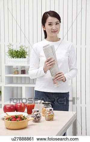 Woman holding newspaper and smiling at the camera View Large Photo Image Stock Image - Woman holding newspaper and smiling at the camera. Fotosearch