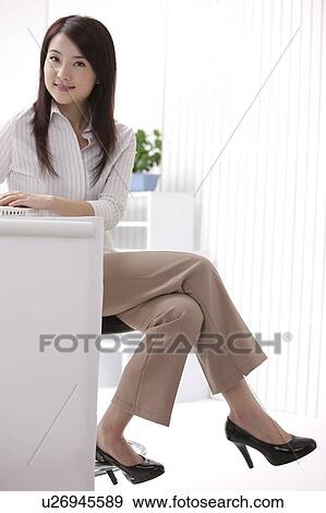 Woman sitting and looking at the camera with smile View Large Photo Image Stock Photo - Woman sitting and looking at the camera with smile. Fotosearch
