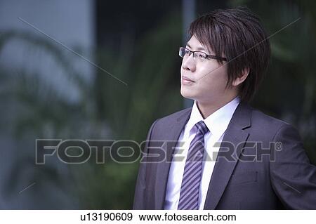 Stock Photo - Young man looking away with well-dressed. Fotosearch