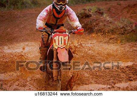 Picture - Young man motocross over field.. Fotosearch