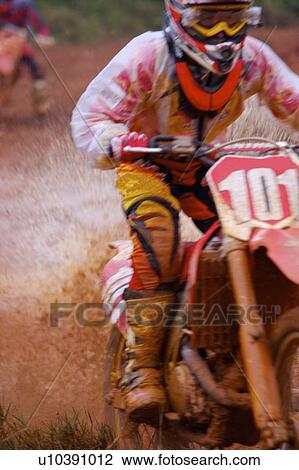 Stock Image - Young man motocross over field.. Fotosearch