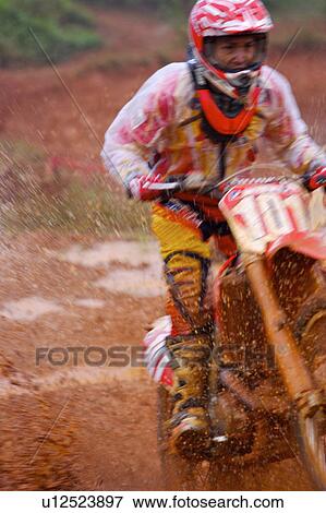 Stock Photo - Young man motocross over field.. Fotosearch