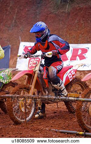 Stock Photo - Young man motocross over field.. Fotosearch