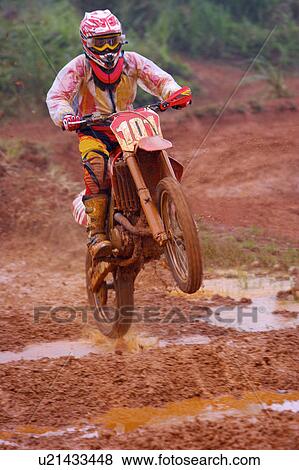 Stock Photo - Young man motocross over field.. Fotosearch