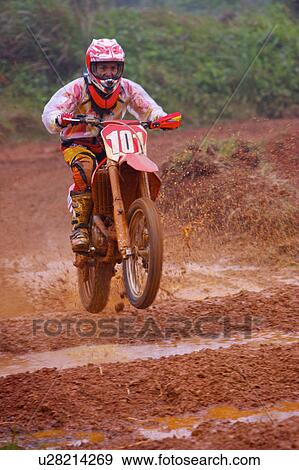 Stock Photo - Young man motocross over field.. Fotosearch
