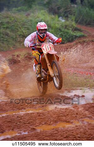 Stock Photography - Young man motocross over field.. Fotosearch