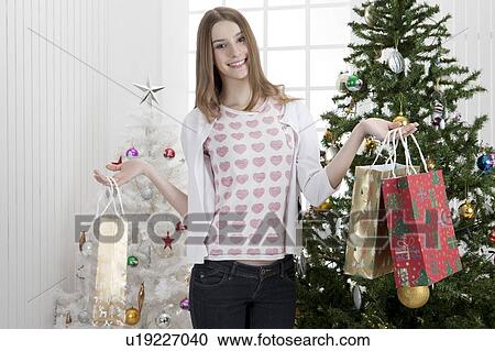 Young woman holding shopping bags and smiling View Large Photo Image Stock Image - Young woman holding shopping bags and smiling. Fotosearch