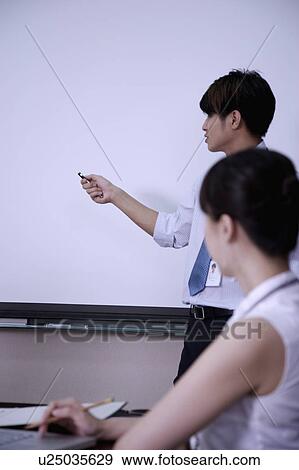 Stock Photo - Young woman listening of young man's introduction in the meeting room. Fotosearch