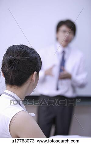 Stock Image - Young woman looking at young man with concentration. Fotosearch