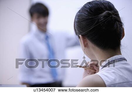 Young woman looking at young man with hand on chin View Large Photo Image Stock Photo - Young woman looking at young man with hand on chin. Fotosearch