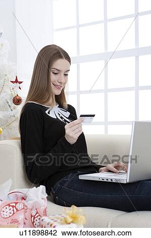 Young woman sitting on sofa and using laptop with smile View Large Photo Image Stock Image - Young woman sitting on sofa and using laptop with smile. Fotosearch
