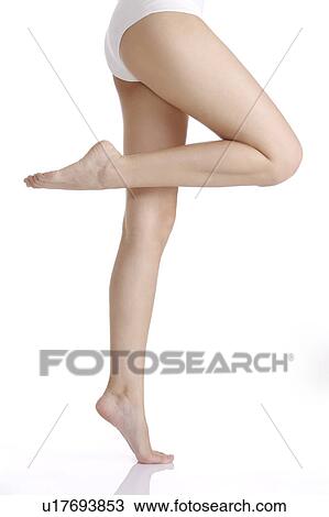 Young woman standing on one leg View Large Photo Image Stock Image - Young woman standing on one leg. Fotosearch