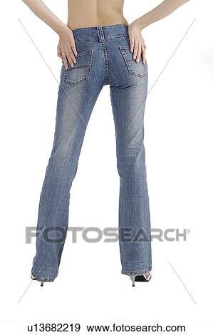 Young woman wearing jeans and standing with hand on hip View Large Photo Image Stock Photo - Young woman wearing jeans and standing with hand on hip. Fotosearch