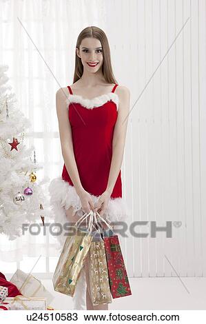 Young woman wearing red dress and holding shopping bags with smile View Large Photo Image Stock Image - Young woman wearing red dress and holding shopping bags with smile. Fotosearch