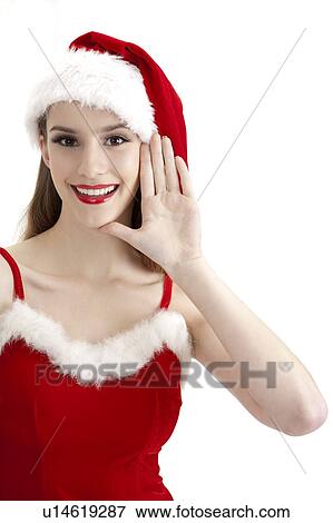 Stock Photo - Young woman wearing Santa hat and gesturing with smile. Fotosearch