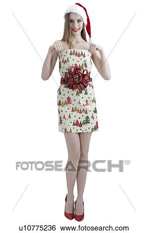 Stock Photograph - Young woman wearing Santa hat and smiling at the camera. Fotosearch