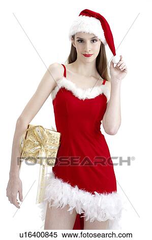 Young woman wearing Santa hat and holding a wrapped gift View Large Photo Image Stock Photography - Young woman wearing Santa hat and holding a wrapped gift. Fotosearch